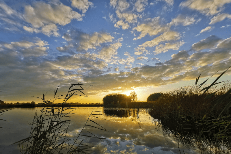 foto van de reeuwijkse plassen met zonsondergang
